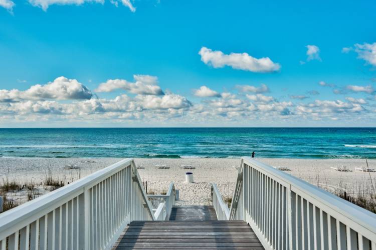 Wooden Boardwalk leading to sandy beach and clear blue ocean